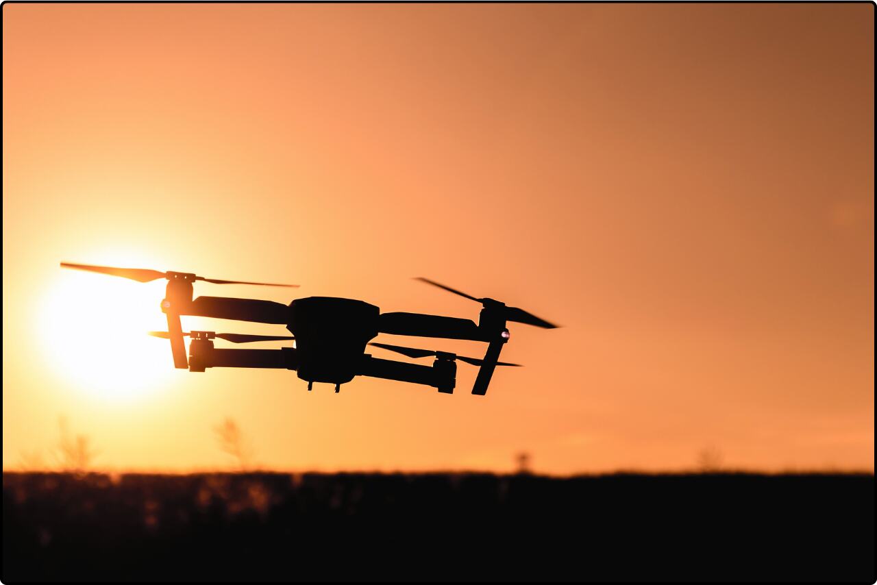 Drone flying in the golden sunset light, camera mounted for aerial photography